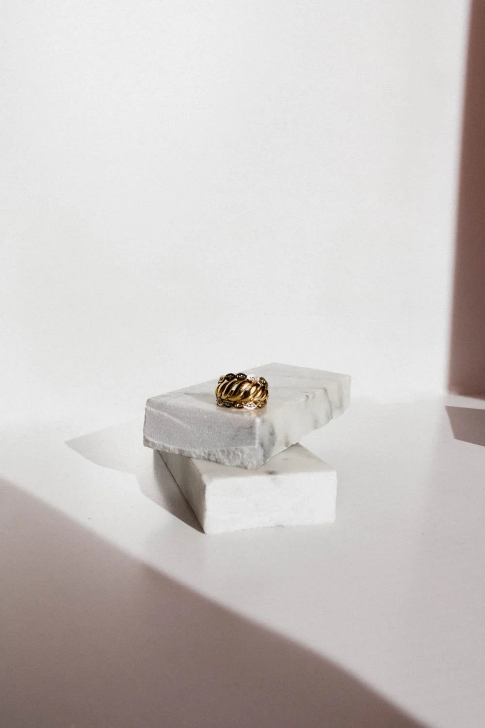 gold ring on marble pieces with a white background 