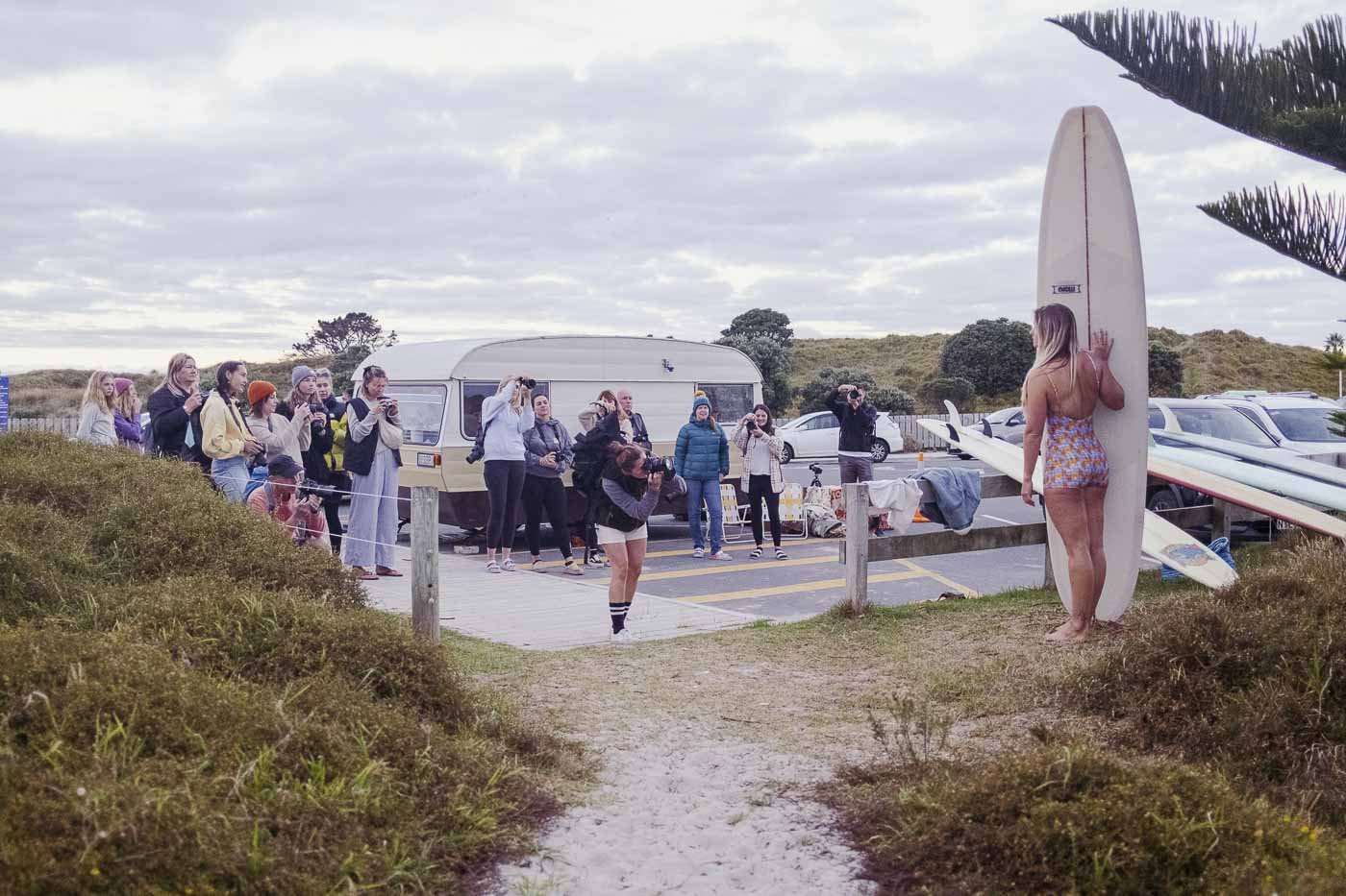 photographers gathered near vintage caravan during Nostalgic Surf styled surf photography workshop location setup and permits coordination beach car park staging area