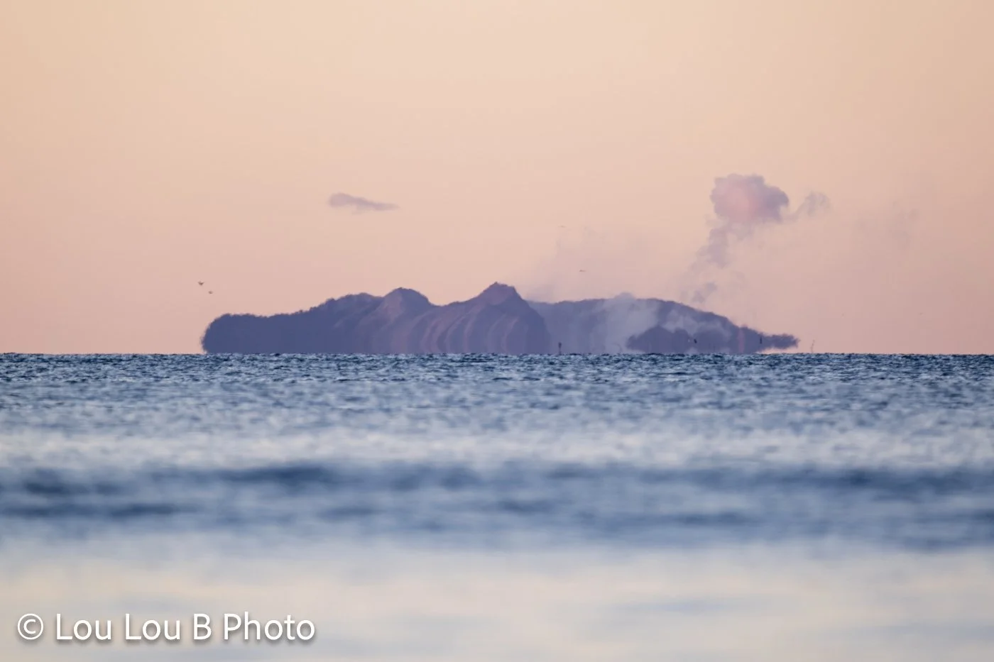 Whakaari / White Island viewed across the ocean at sunset, Bay of Plenty, New Zealand
