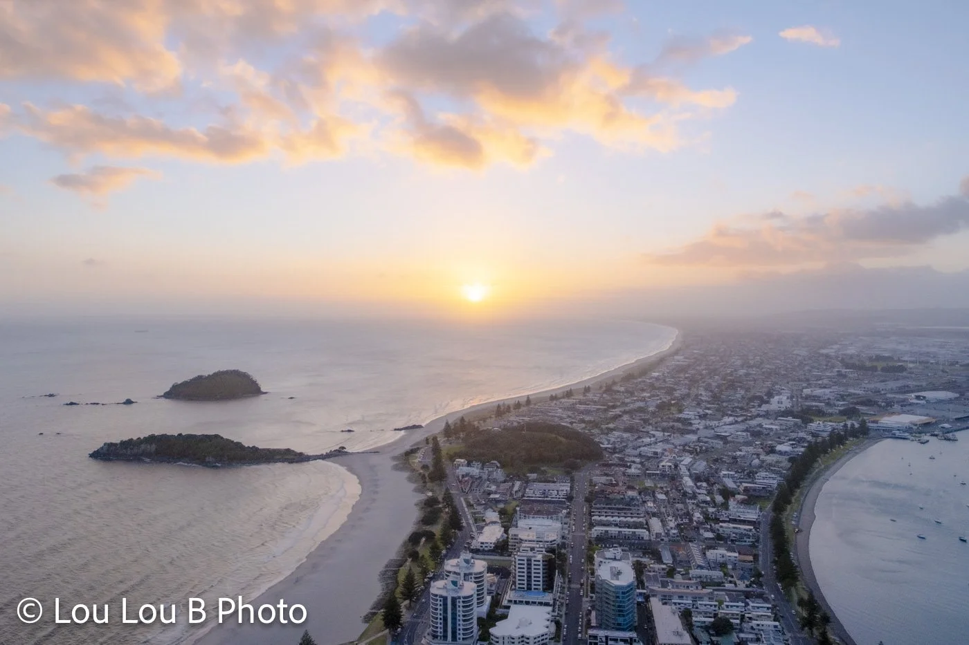 Aerial view over Mount Maunganui coastline from Mauao summit, Moturiki Leisure Island at sunrise