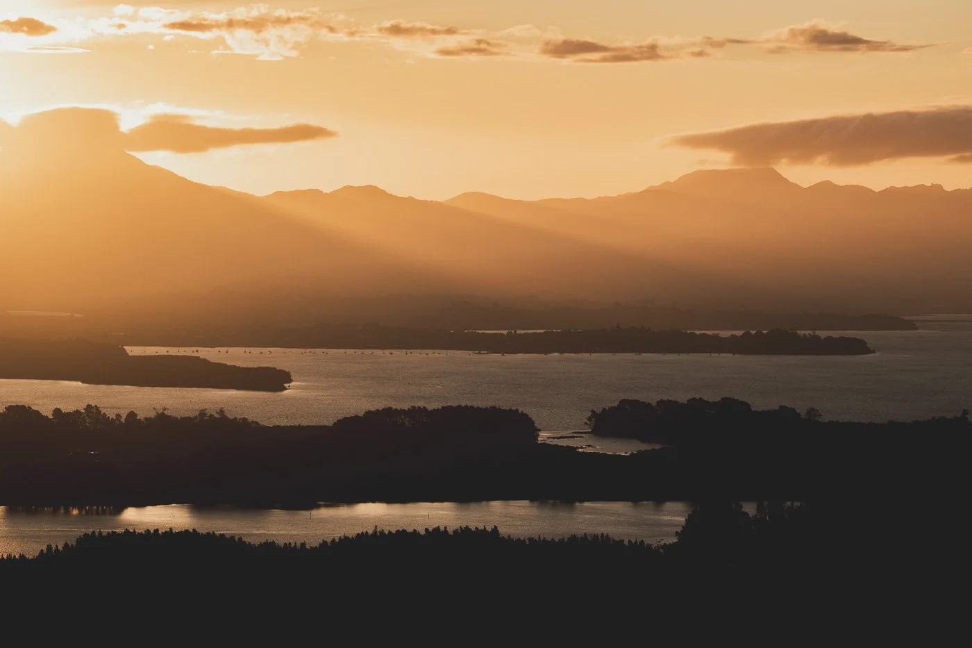 Sunset view from Mauao summit Mount Maunganui looking across Tauranga Harbour toward the Kaimai Range