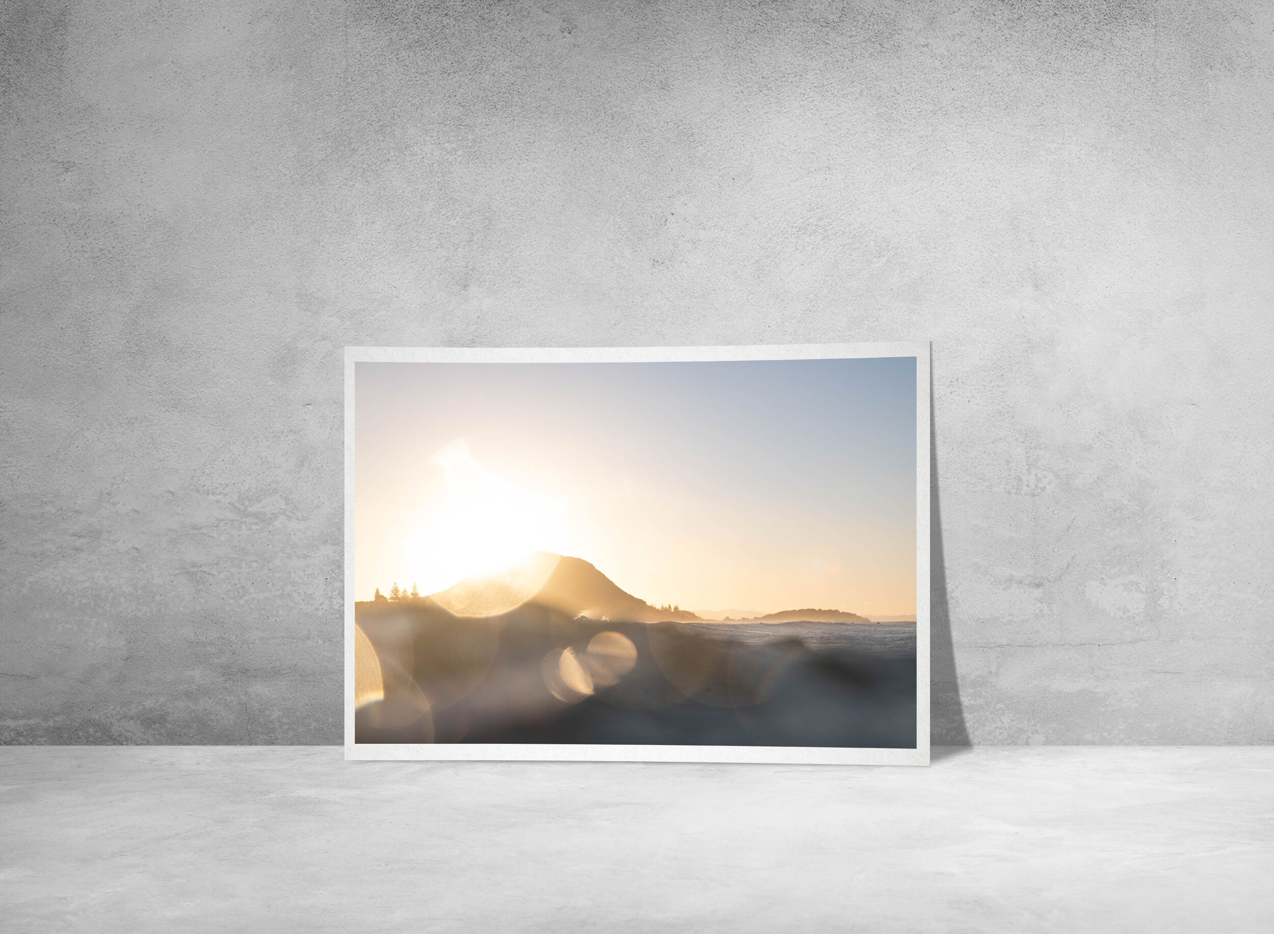 Fine art photographic print of Mount Maunganui at sunset, featuring bokeh of the golden light over the ocean.