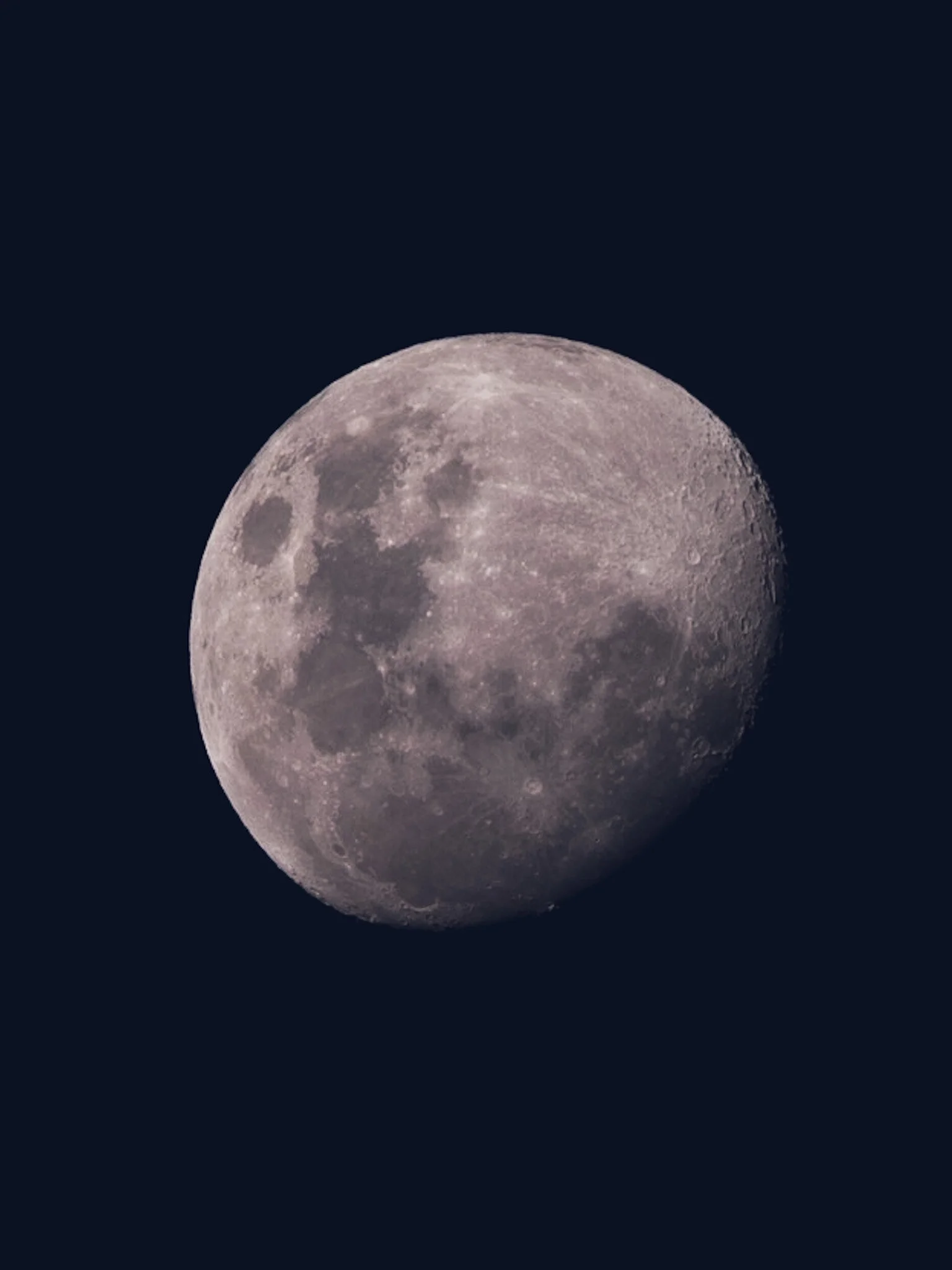 Immerse yourself in the magical beauty of this waxing gibbous moon photograph by Lou Lou B Photo, evoking the enchanting charm of silver glitter dust. The stark contrast against the dark blue background creates a mesmerizing and captivating image, hi