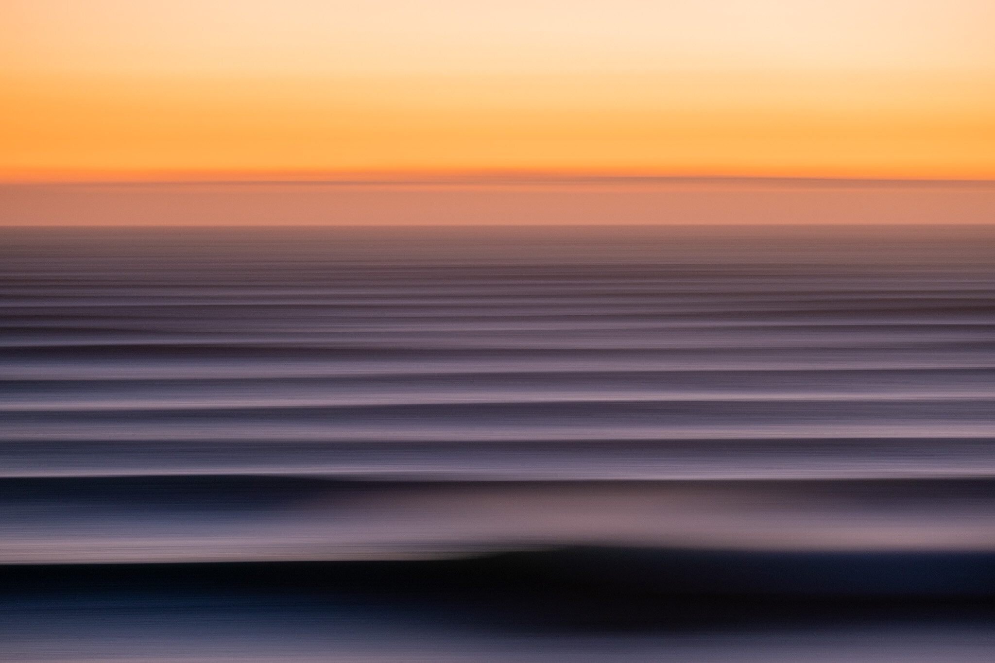 Abstract fine art photo of massive cyclone swell waves at blue hour in Mount Maunganui, NZ. Emotive slow shutter panning style shot creates the perfect surf lifestyle photo by Lou Lou B Photo.