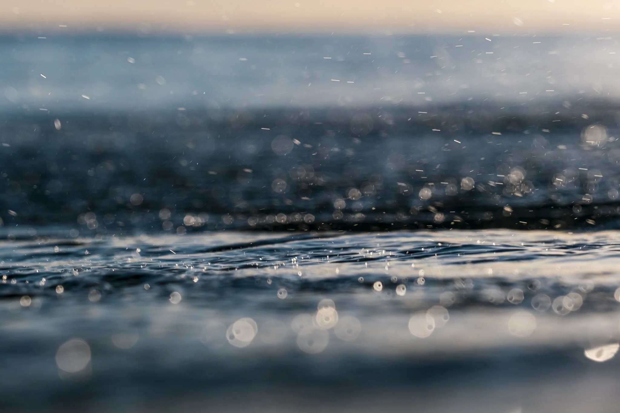 Backlit ocean spray and surface reflections showing light scattering across moving water