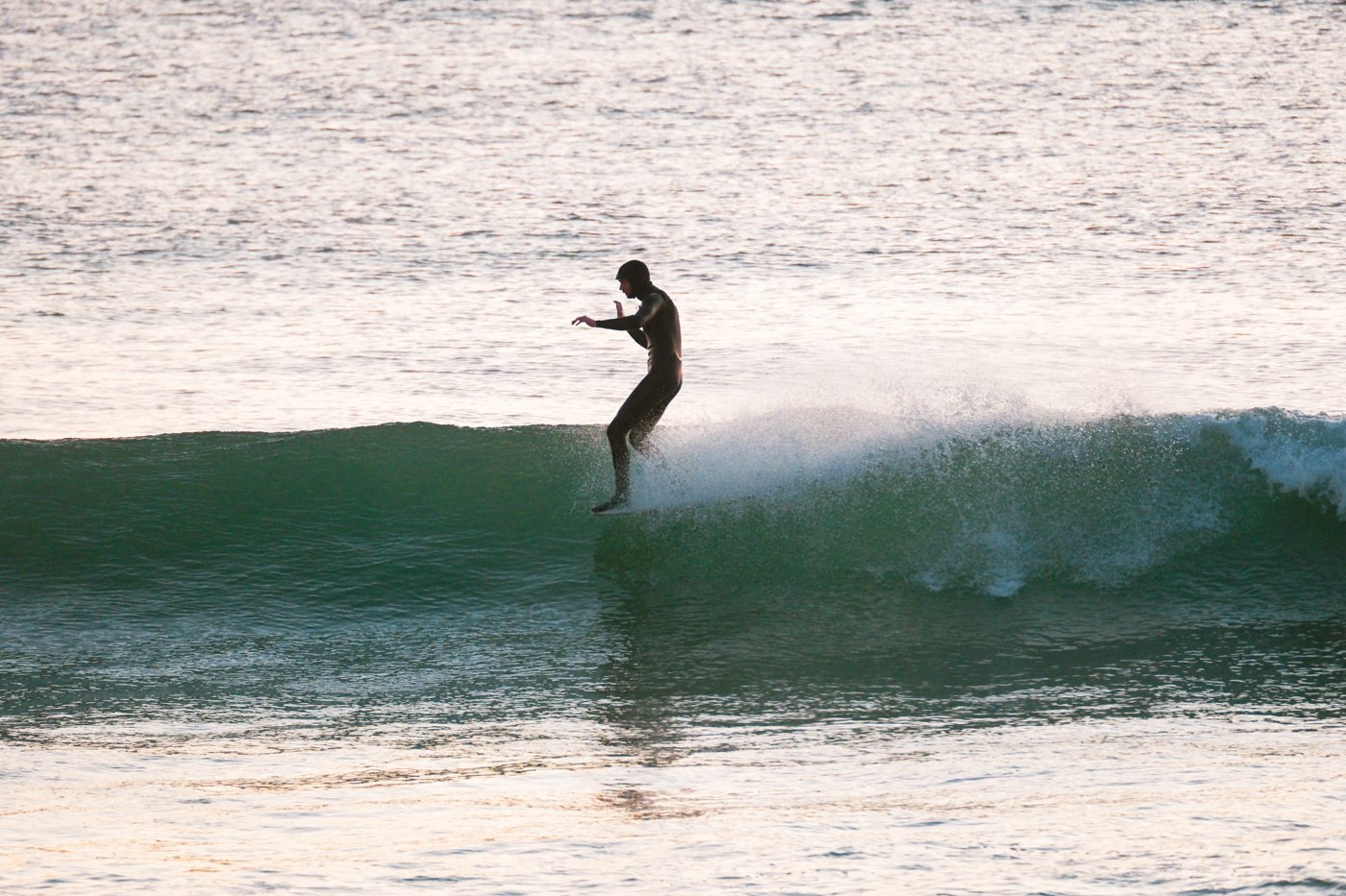 shoreline surf photography example showing surfer riding wave from beach perspective