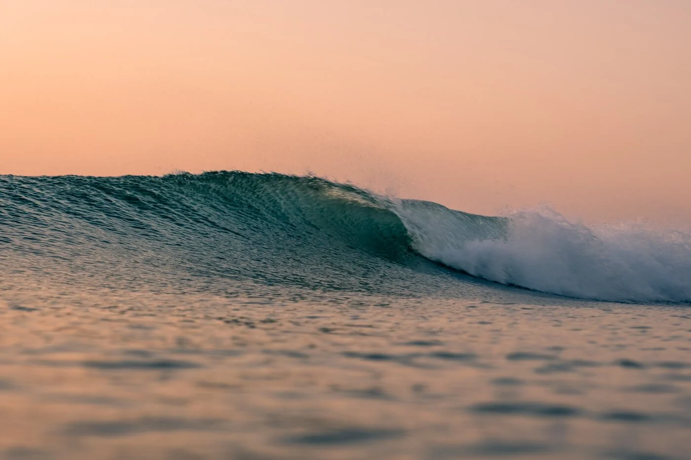 wave face photographed from water level using 16–55mm lens in surf photography