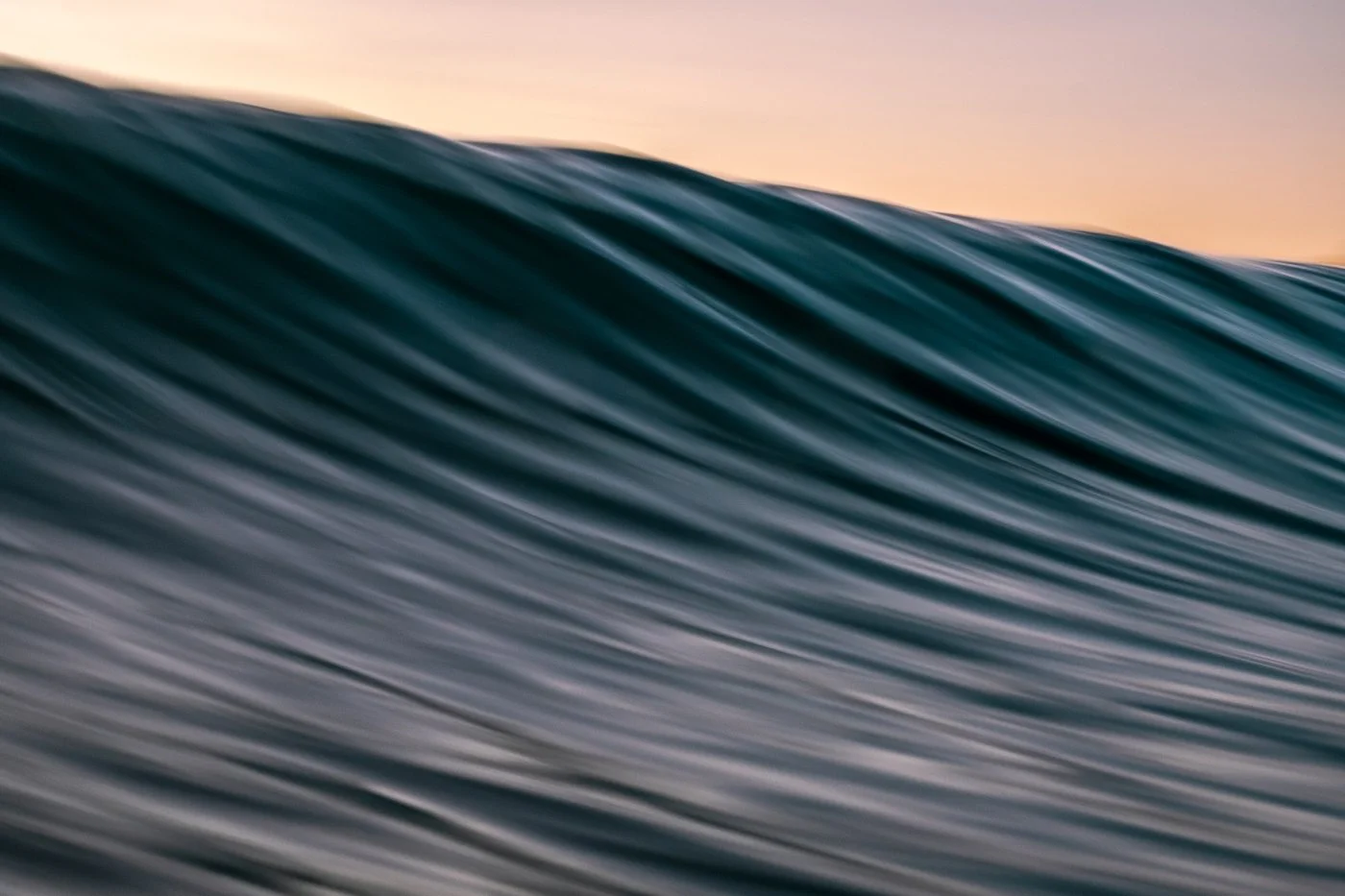 Close-up ocean texture photographed with slower shutter speed showing flowing movement across the wave face.