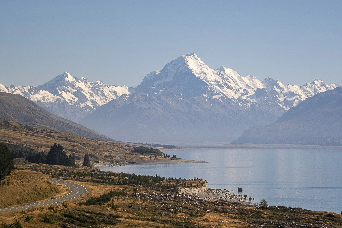Aoraki / Mount Cook rising above Lake Pukaki and the road into Aoraki / Mount Cook National Park, New Zealand.