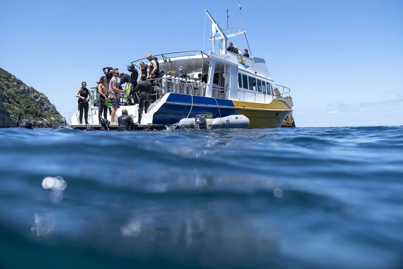 Dive boat floating on blue water at the Poor Knights Islands marine reserve in Northland, New Zealand.
