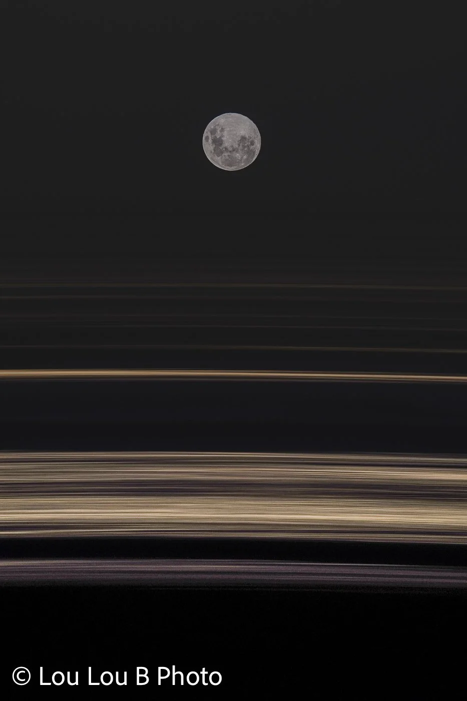 Small full moon above abstract horizontal streaks of light against a dark night sky.