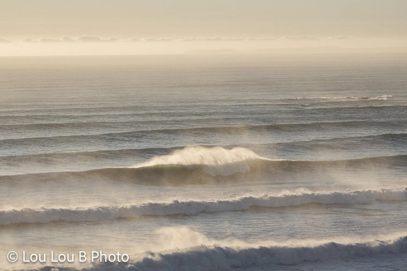 Layers of breaking ocean waves illuminated by soft golden coastal light at Mount Maunganui Main Beach.