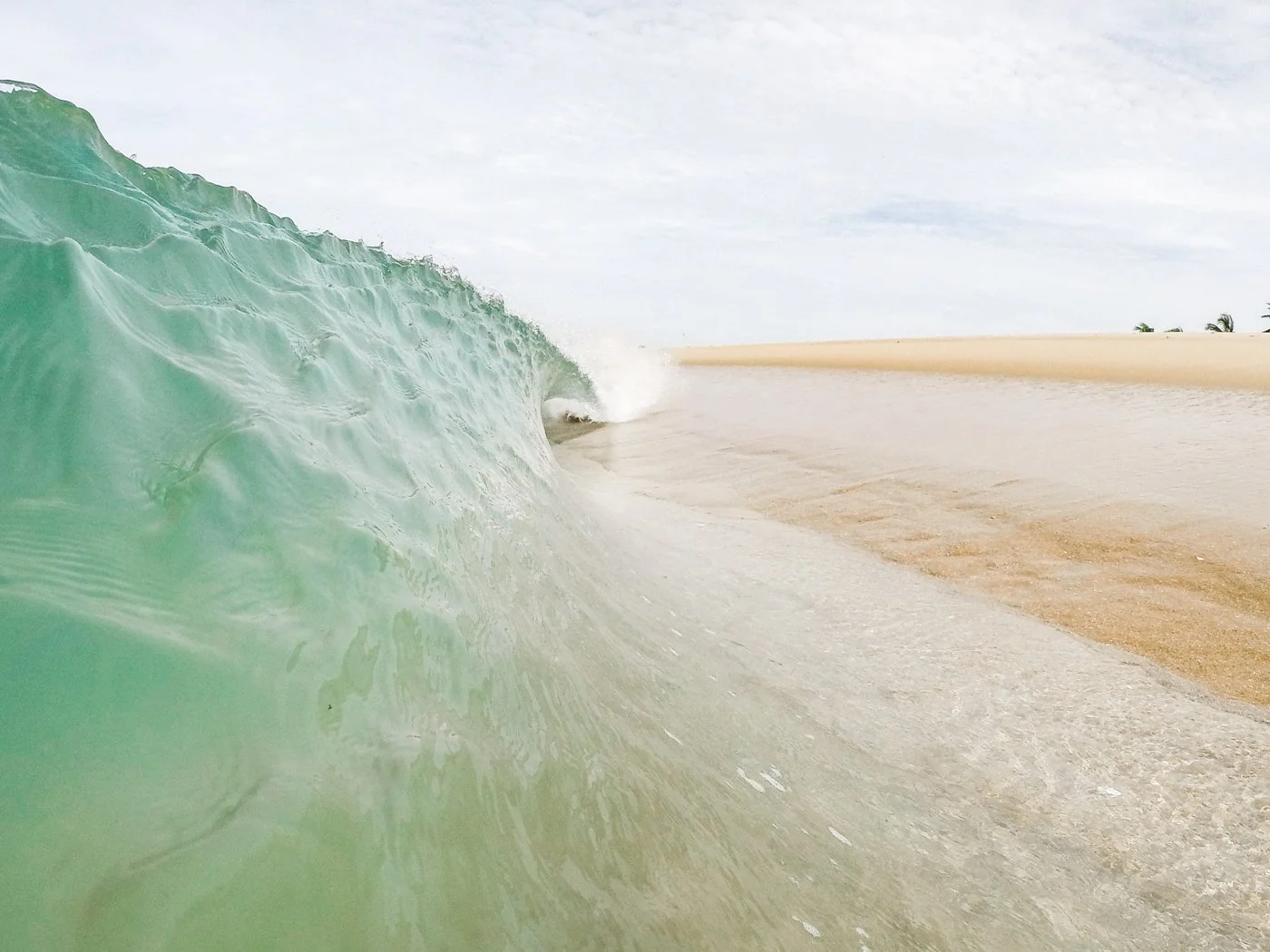 Surf photograph of a breaking wave taken from water level while learning surf photography with a GoPro