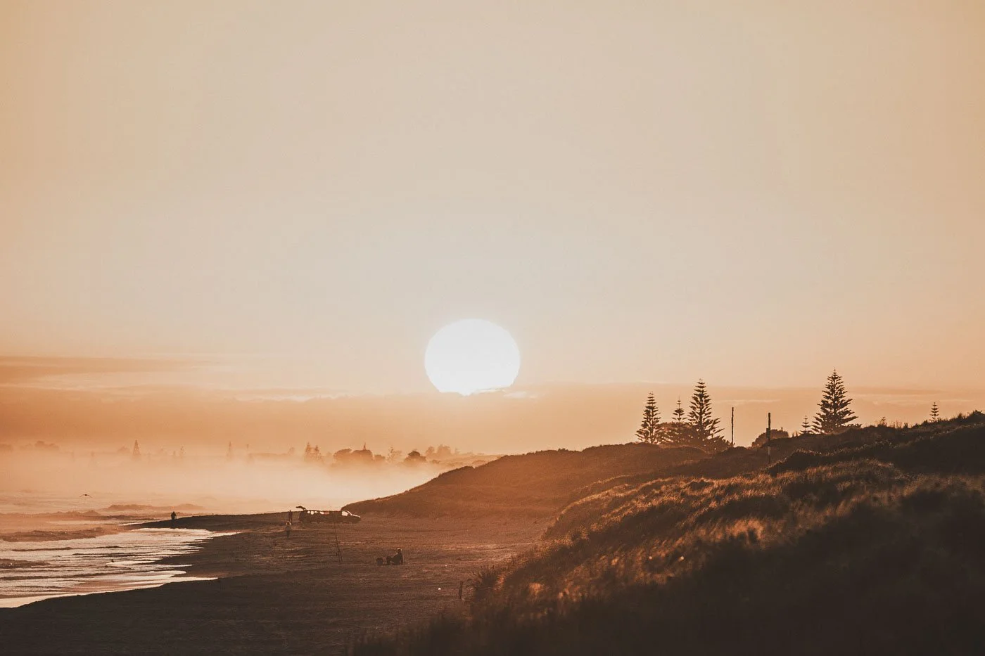 Mid summer sunrise over Papamoa Beach near Mount Maunganui with open horizon coastline and morning mist