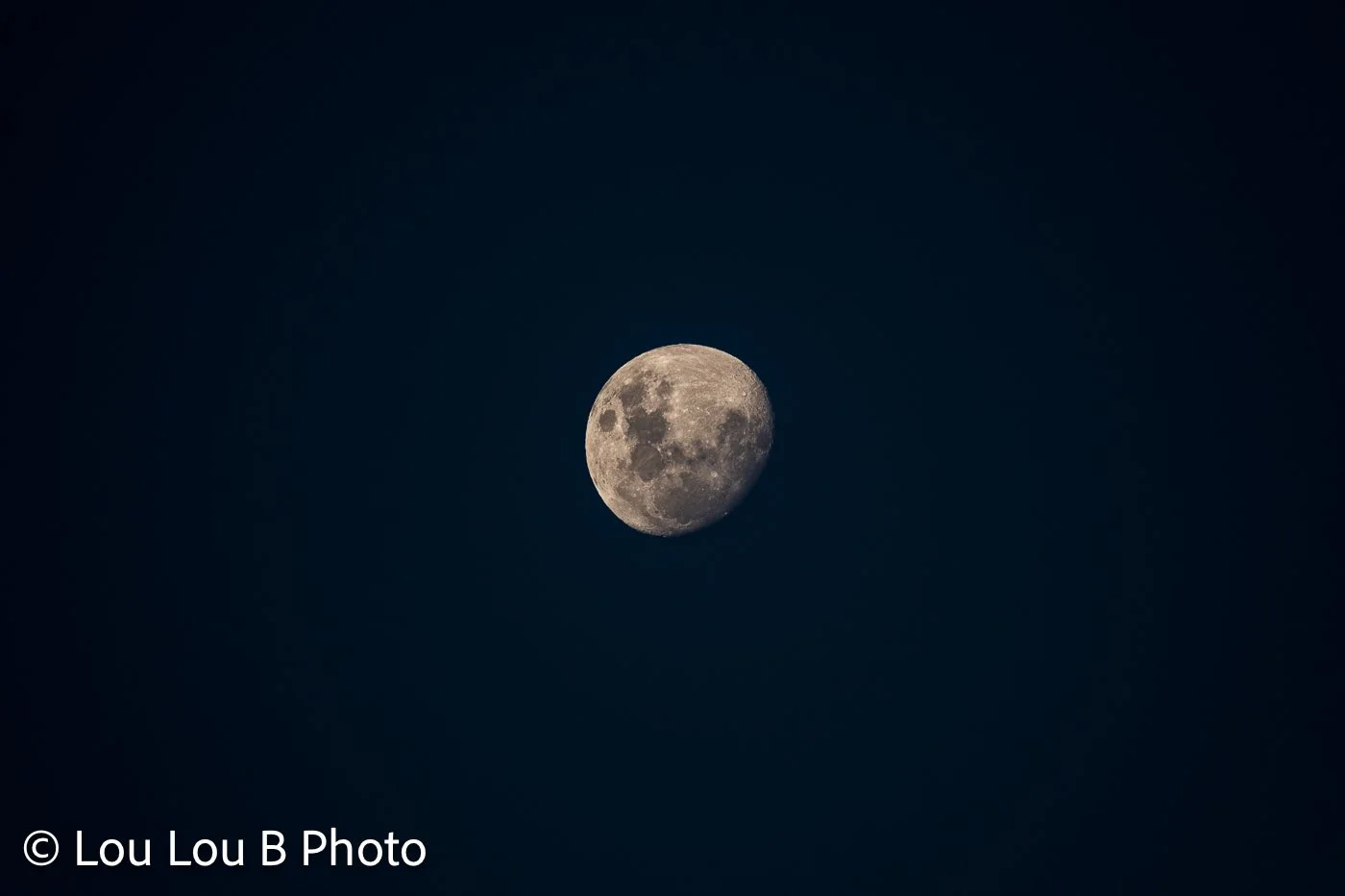 Detailed waxing moon against a deep navy blue night sky.