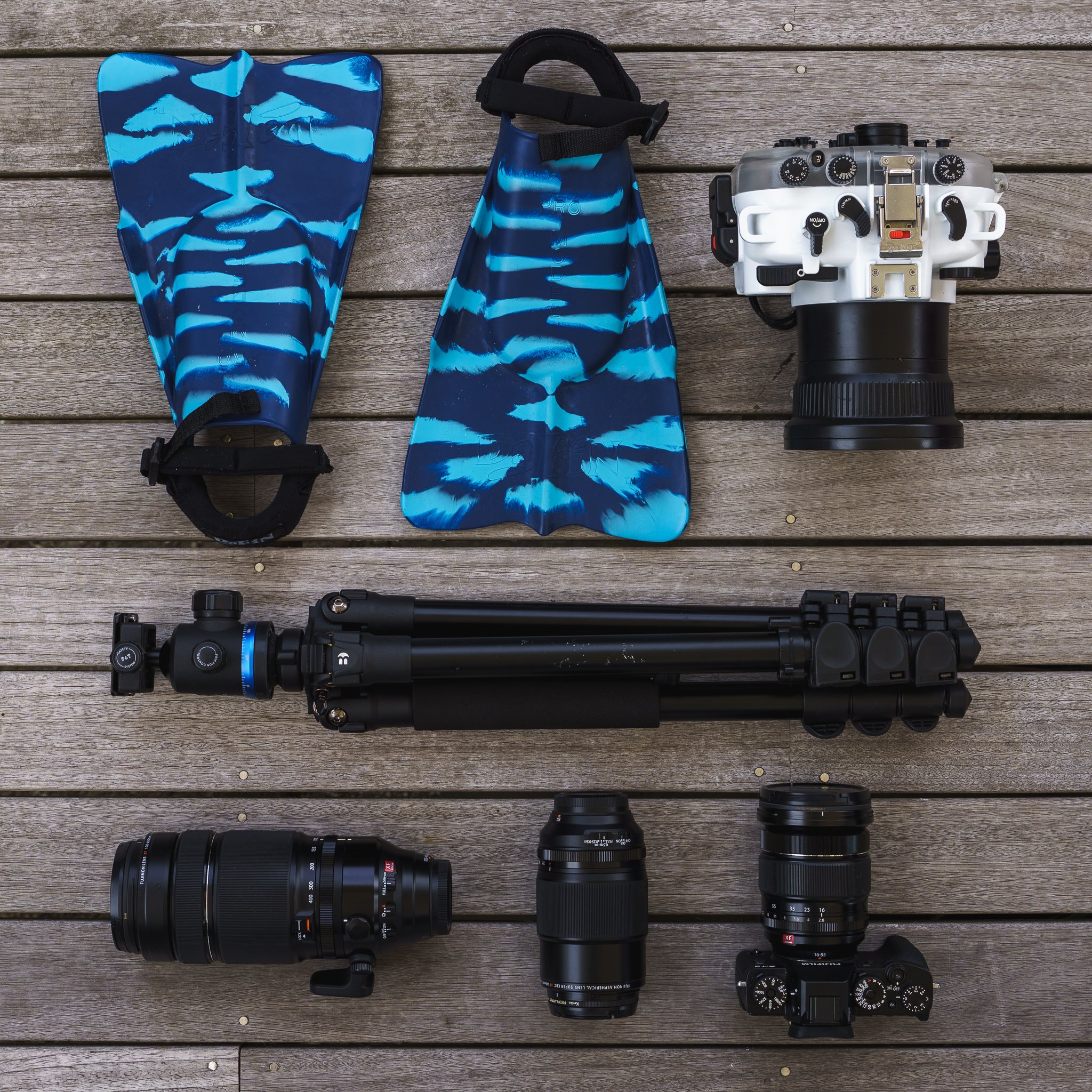 minimal in-water surf photography gear setup with swim fins water housing mirrorless camera lenses and tripod