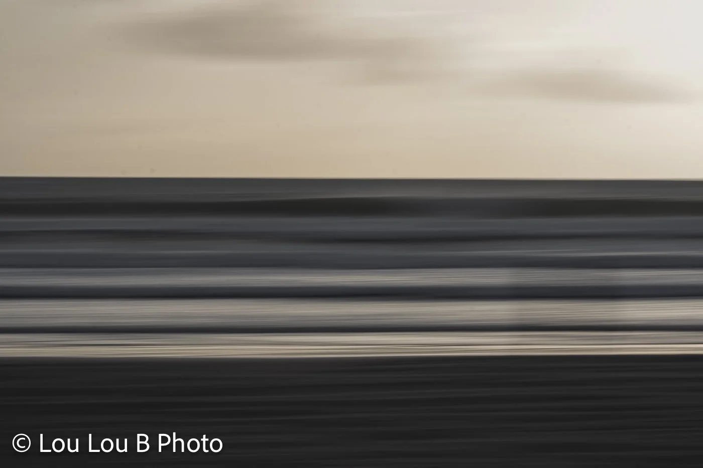 Abstract long-exposure seascape with blurred horizontal bands of ocean, sky and moving water.