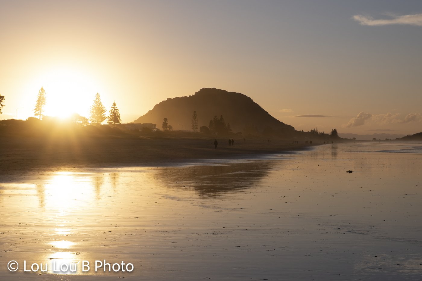 Mauao and Mount Maunganui beach illuminated by golden sunset light