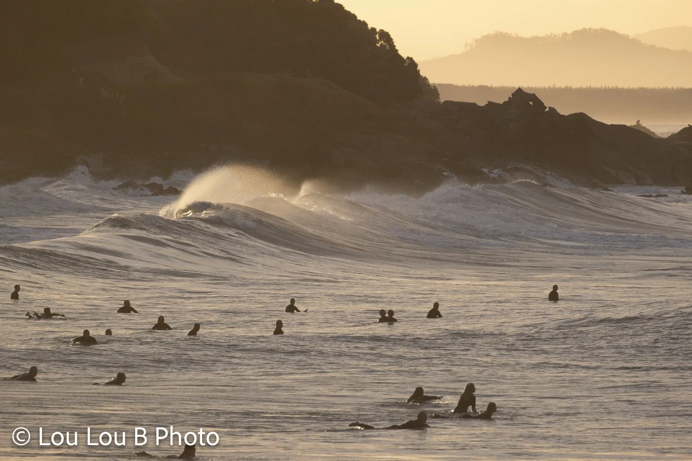 Surfers waiting in the lineup beneath breaking waves at Mount Maunganui