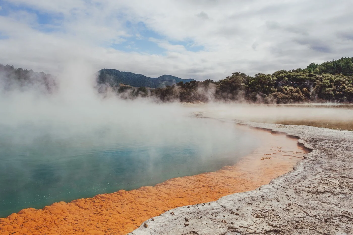 Colourful geothermal pool and steaming landscape at  Waiotapu Thermal Wonderland near Rotorua, New Zealand
