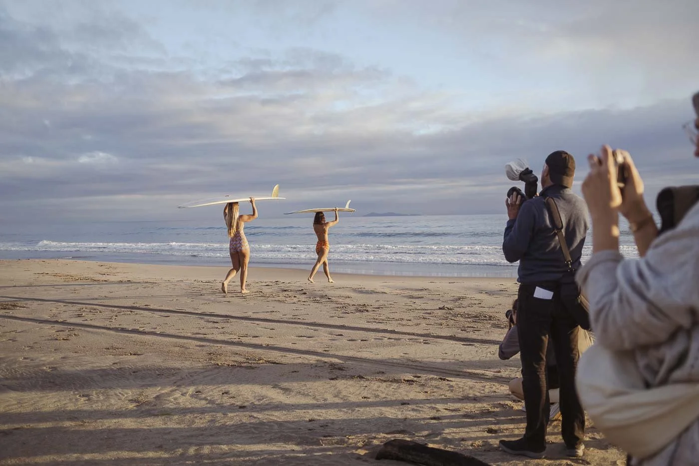 photographers capturing surfers walking along shoreline during Nostalgic Surf styled surf photography workshop campaign shoot sequencing lifestyle movement beach session