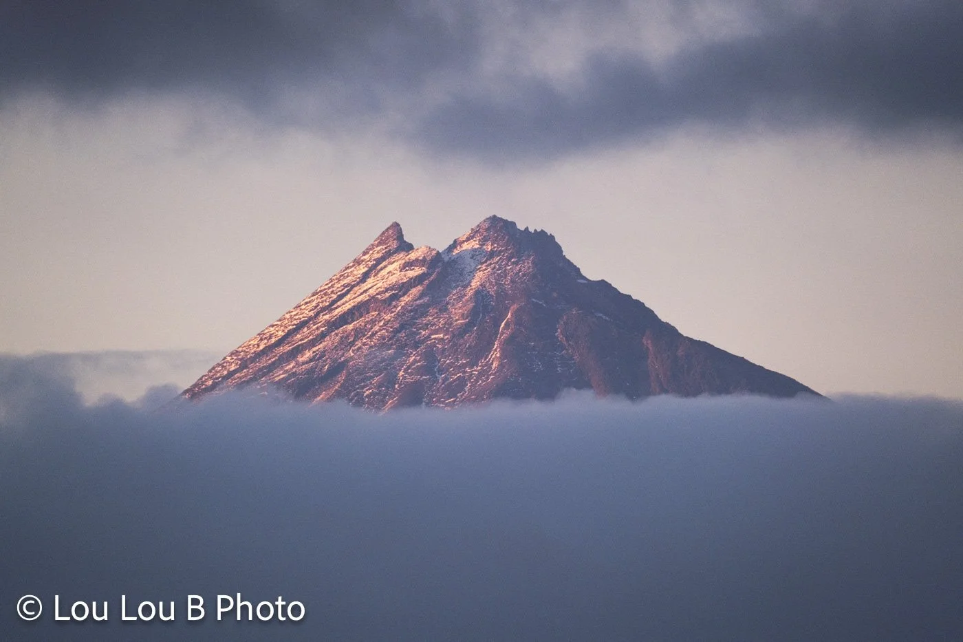 Mount Taranaki, Egmont peak emerging through cloud at sunrise, New Zealand