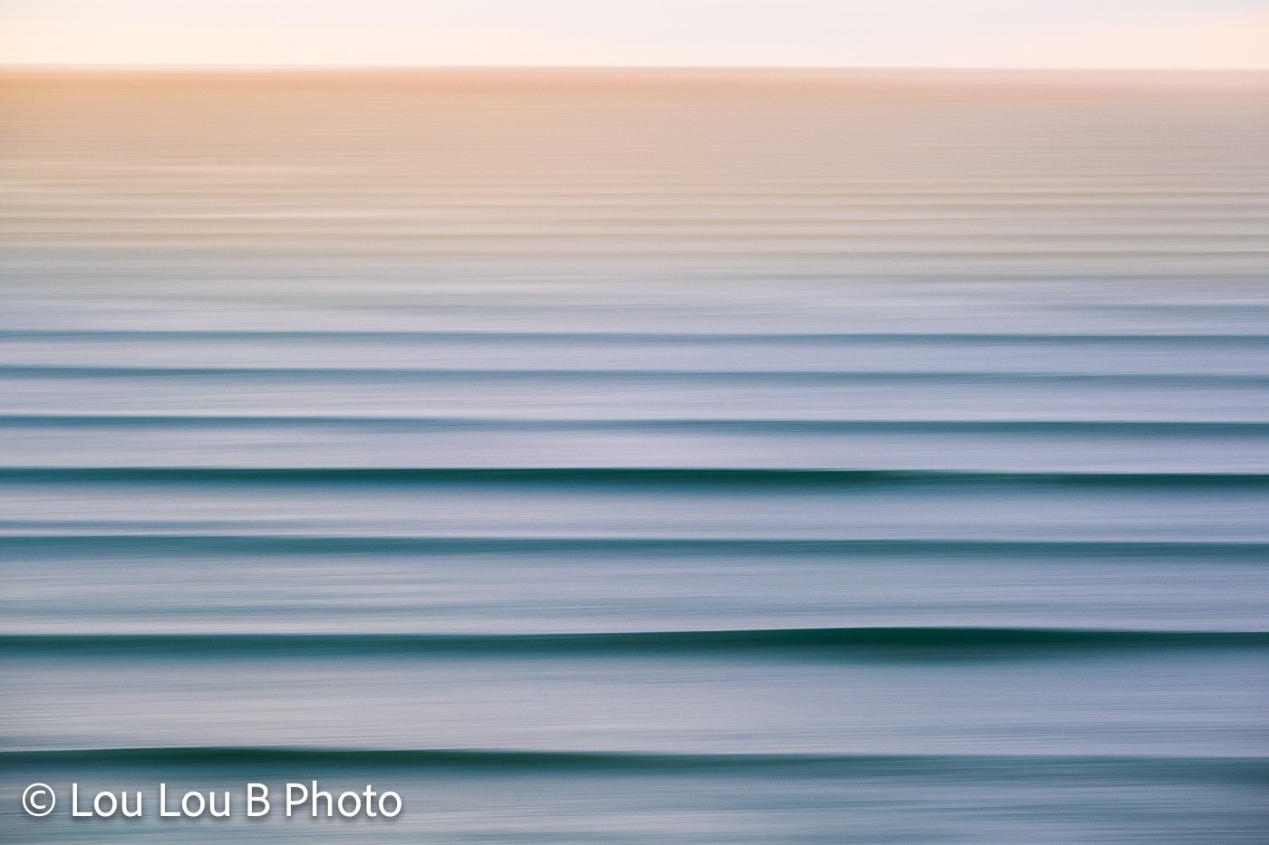 Abstract long-exposure ocean photograph with smooth horizontal lines of turquoise, blue and soft pink.