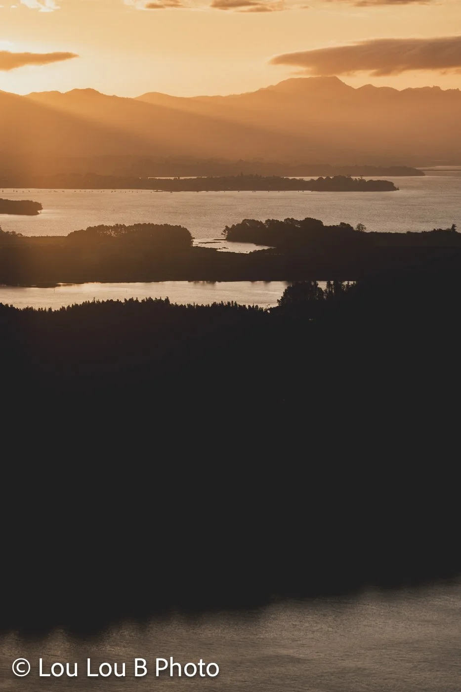 View across the Bay of Plenty coastline and offshore islands from Mauao at golden hour sunset over the Kaimais, Matakana Island and Omokoroa