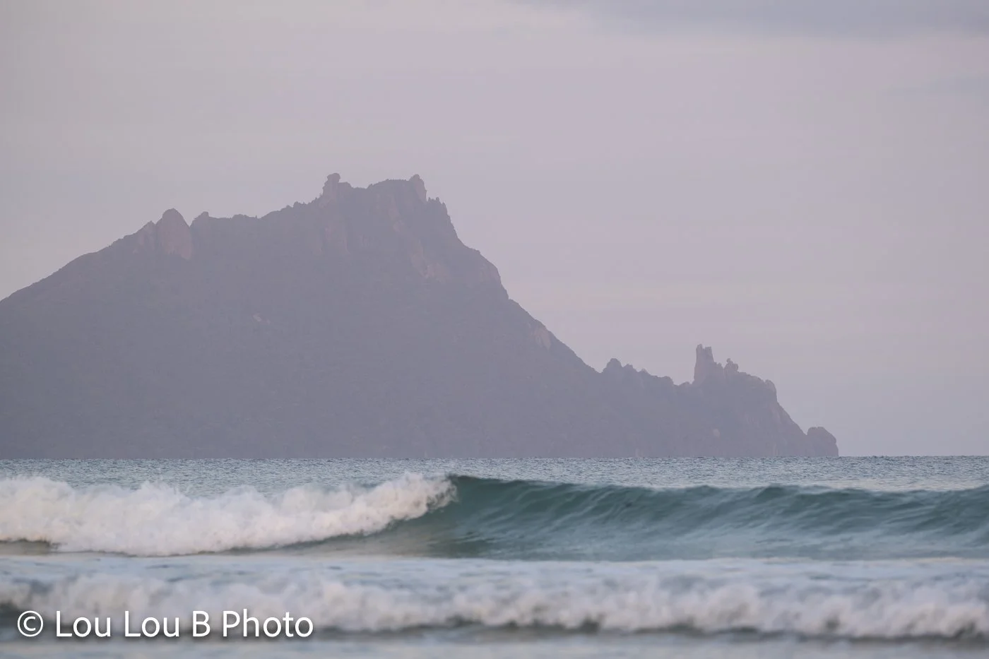 Bream Head rising behind ocean waves, Whangārei Heads, Northland, New Zealand