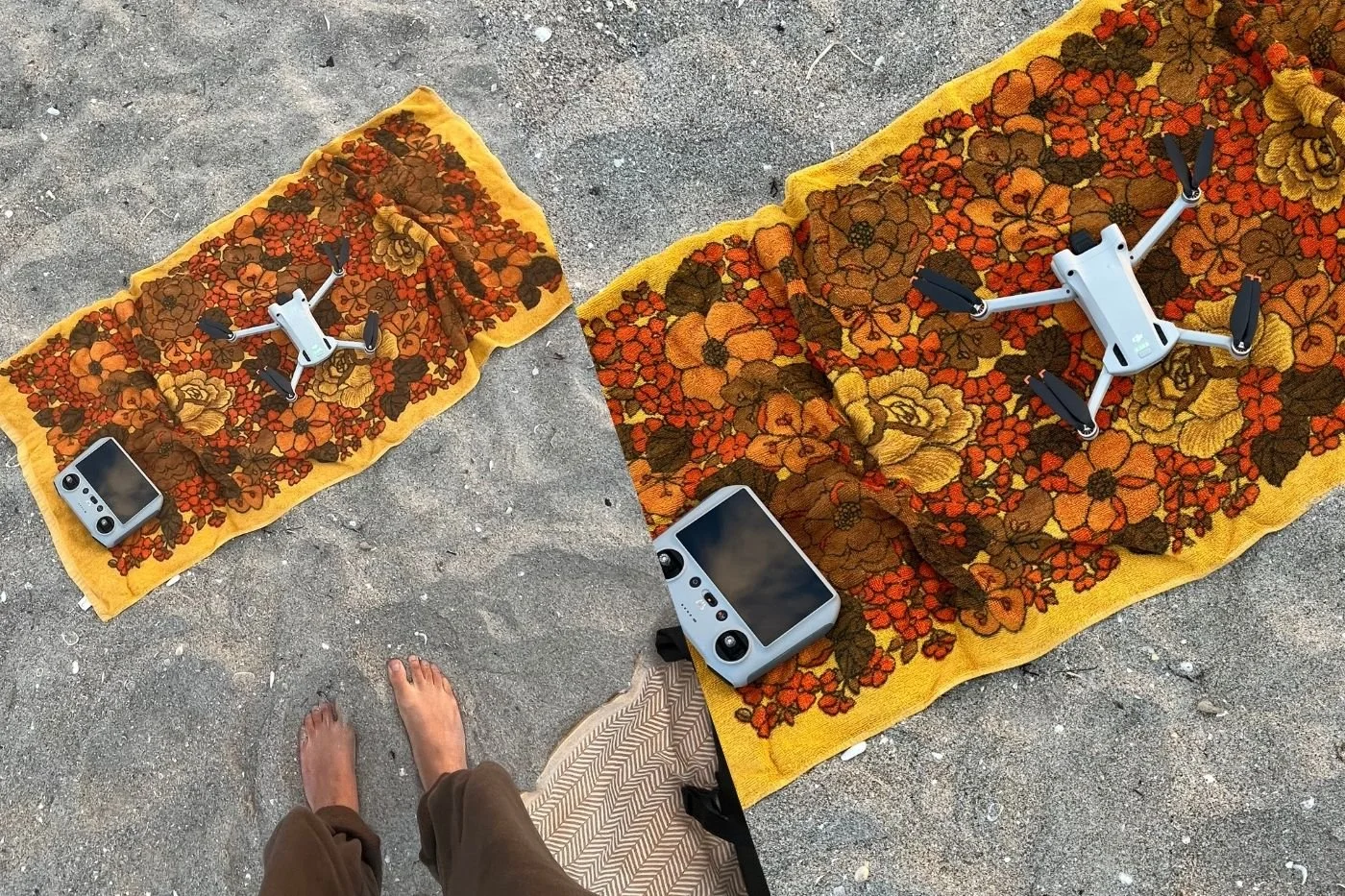 Drone and controller placed on towels to keep them off the beach sand