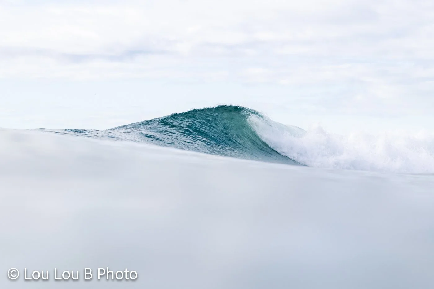 Turquoise breaking wave photographed from the water at Mount Maunganui