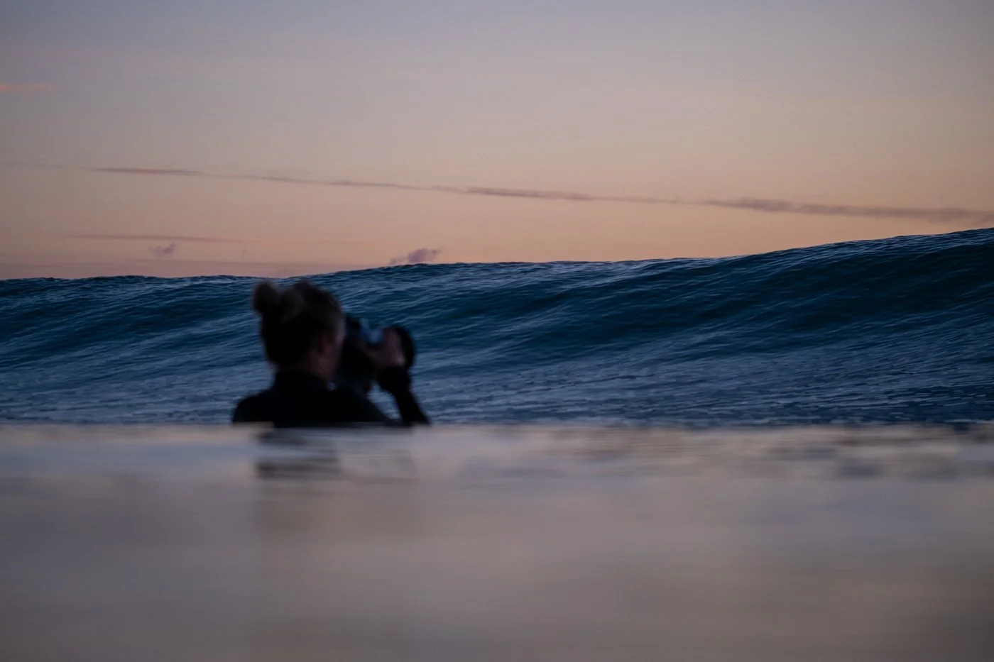 surf photographer watching approaching wave inside lineup water level perspective