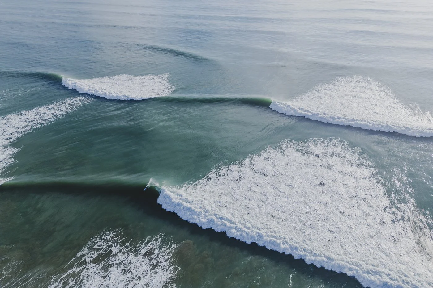 Aerial surf photography showing wave patterns and ocean swell lines from above in Papamoa New Zealand