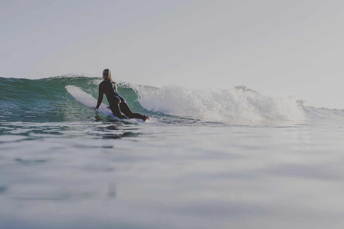 Surfer paddling into a wave at Mount Maunganui in the Bay of Plenty, New Zealand.