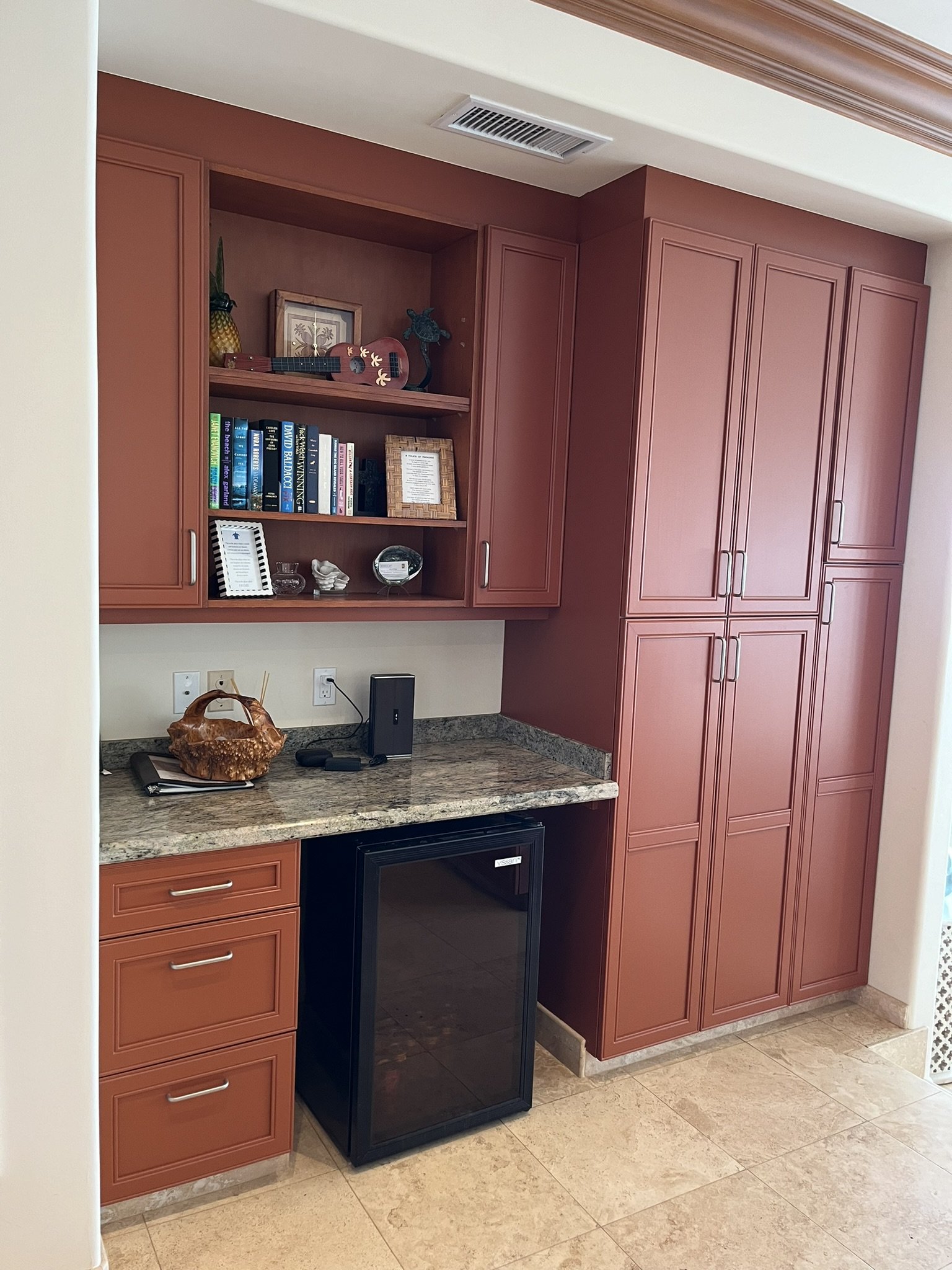 Cabinet refinishing in a Maui home kitchen - pinkish-red wood cabinets with granite countertop and open shelving, by Maui Home Refinishing.