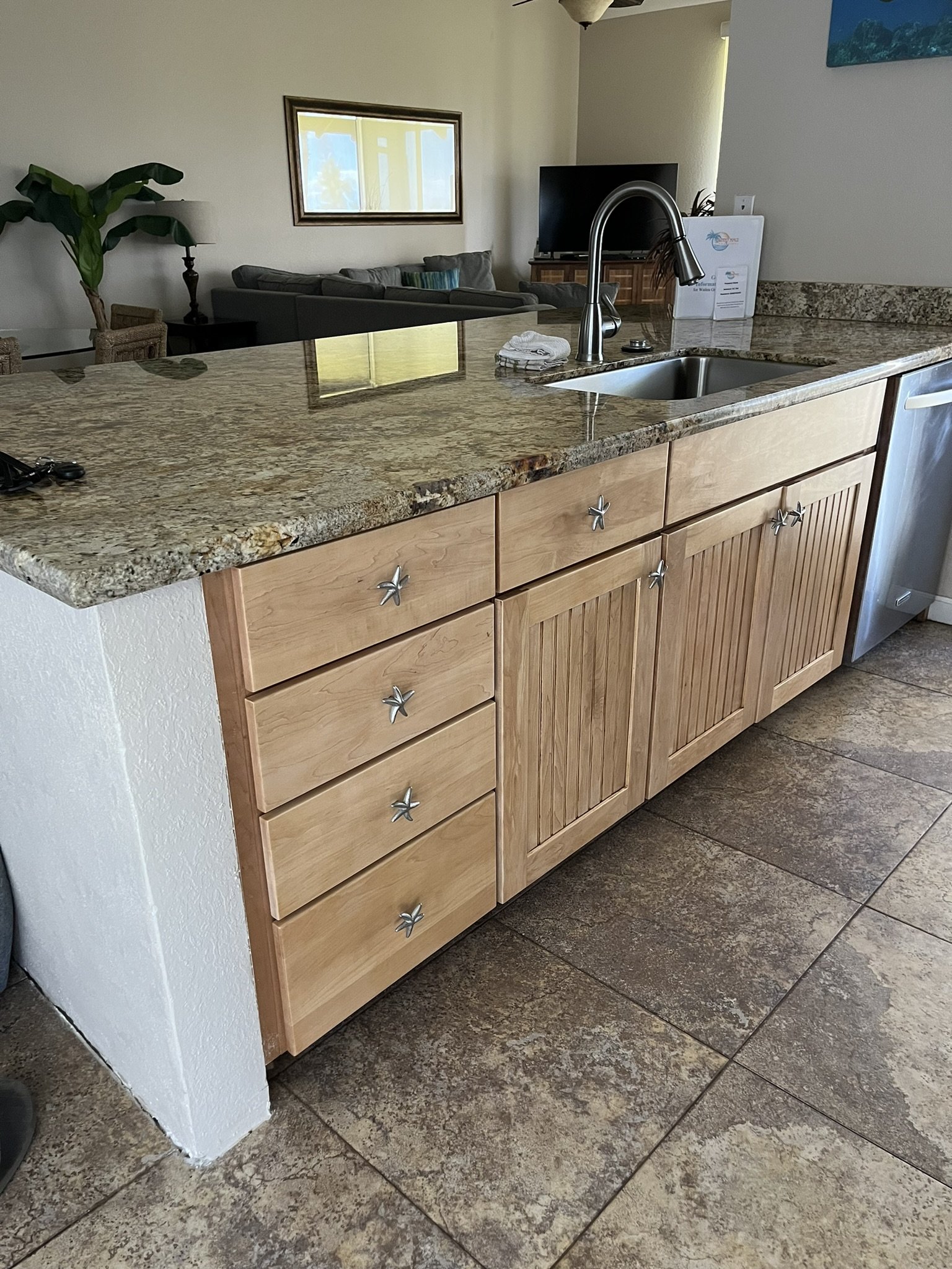 Cabinet refinishing in a Maui home kitchen - countertop with sink, faucet, and refinished wood cabinet drawers, by Maui Home Refinishing.