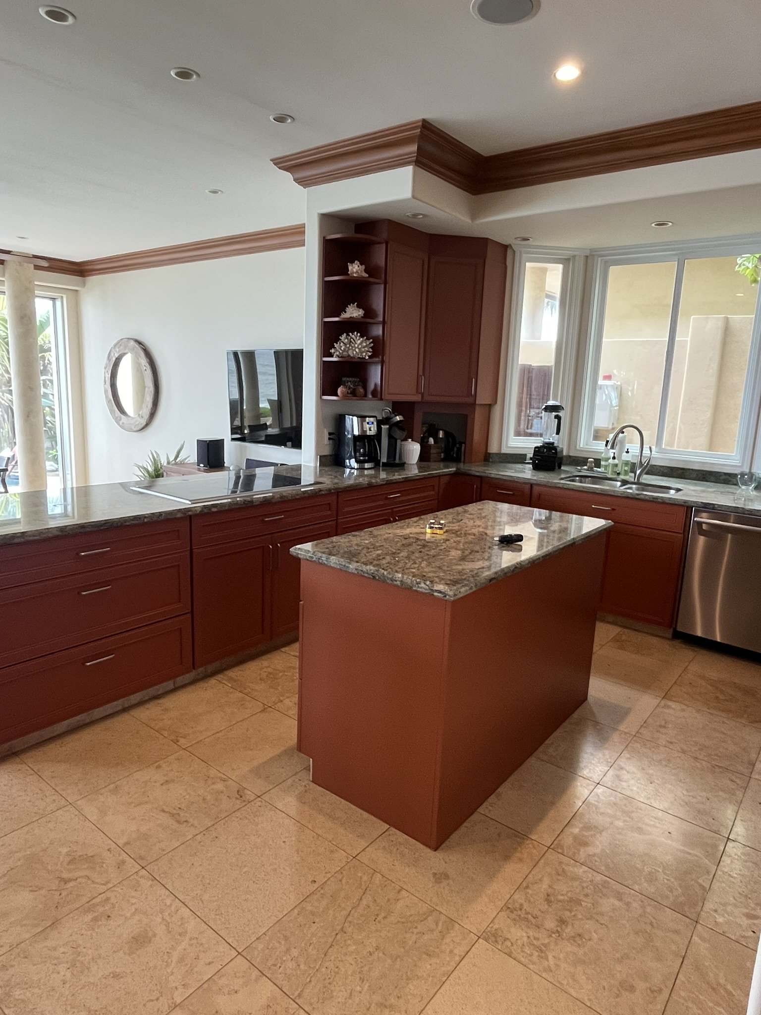 Cabinet refinishing in a Maui home kitchen - reddish wood cabinets with granite countertop island, by Maui Home Refinishing.