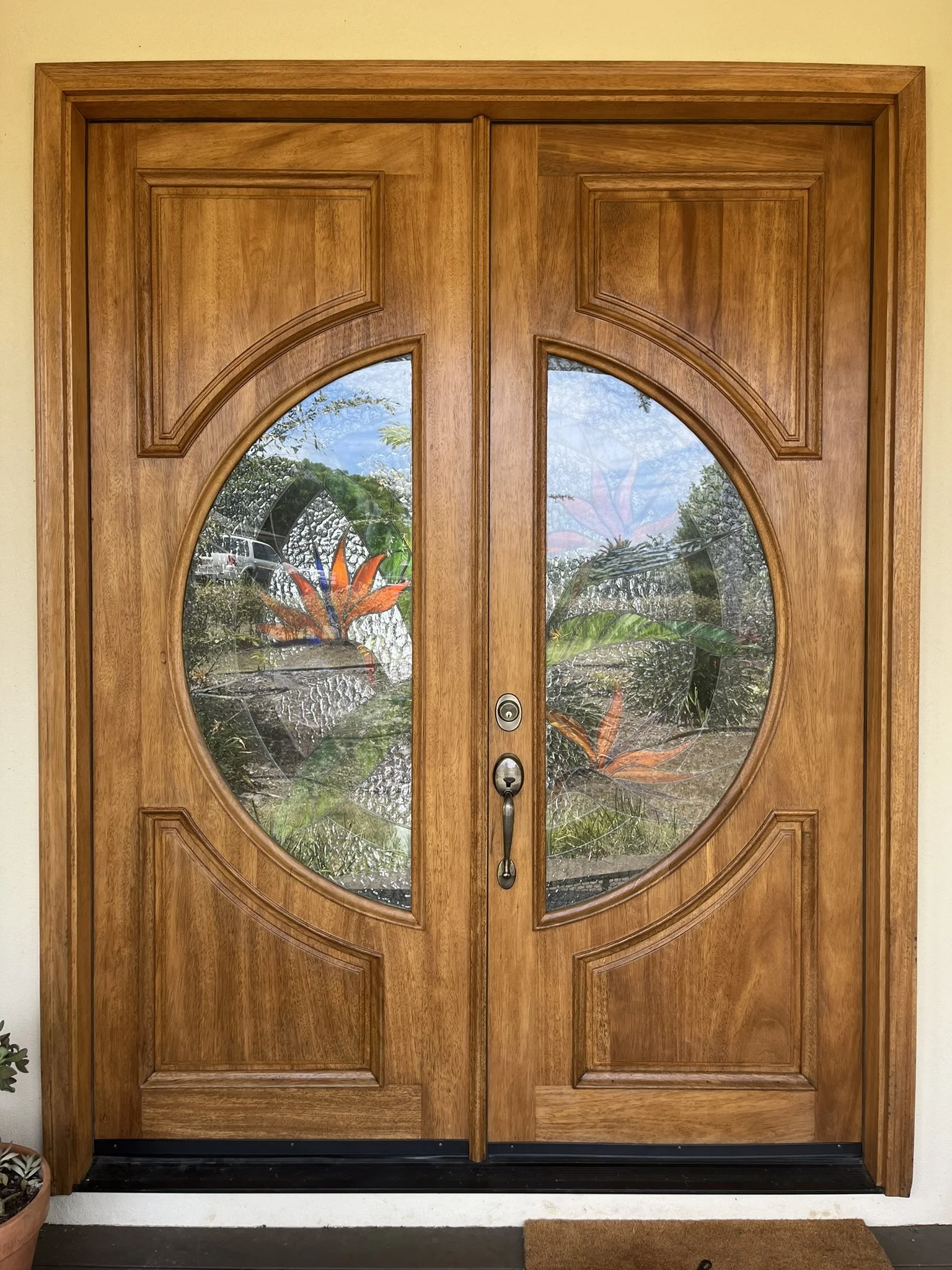 Hardwood front door refinishing in a Maui home - wood door with decorative glass panels, by Maui Home Refinishing.