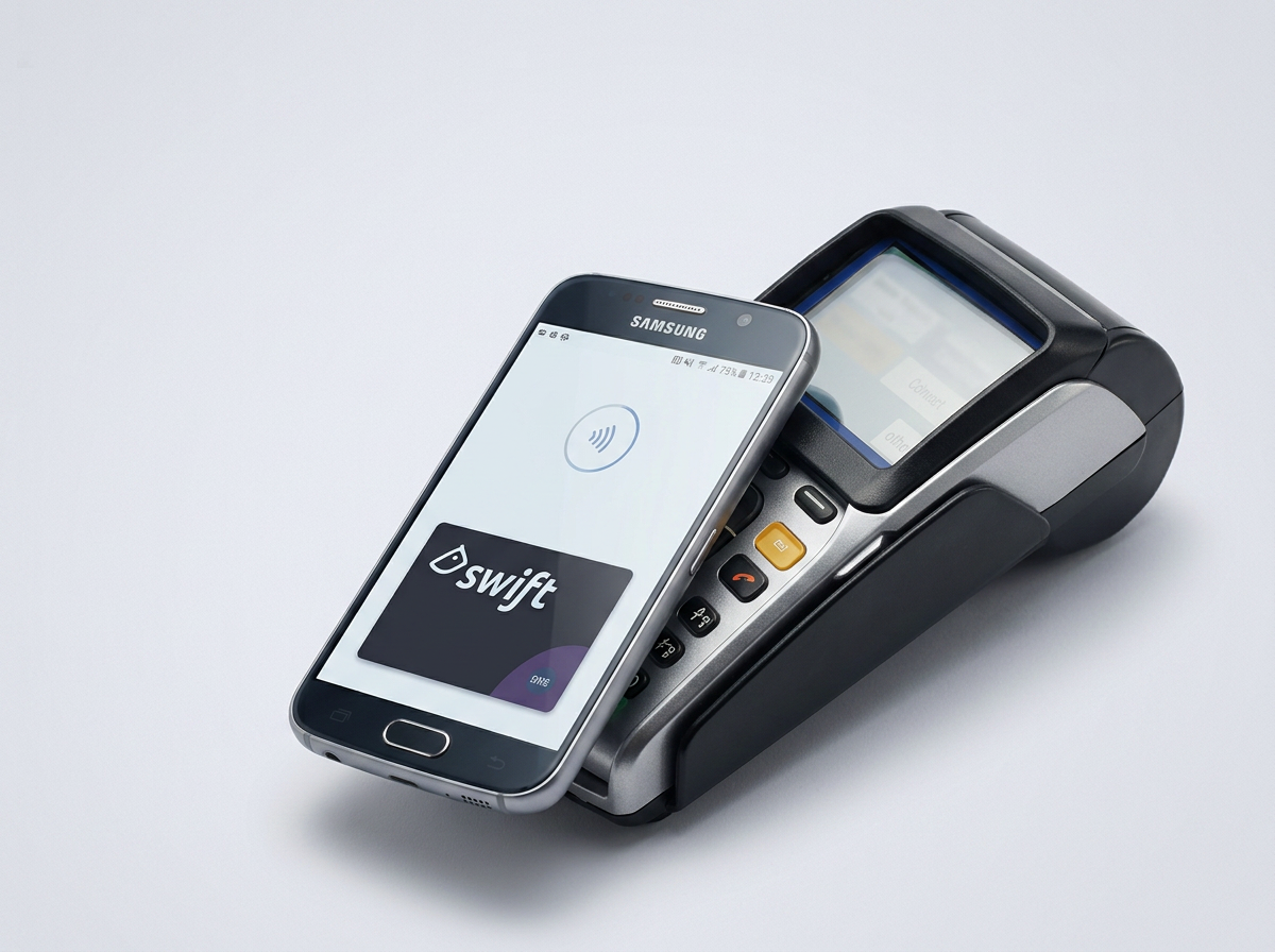 A Samsung smartphone with a contactless payment screen displaying the Swift card, placed on a point-of-sale terminal for payment.