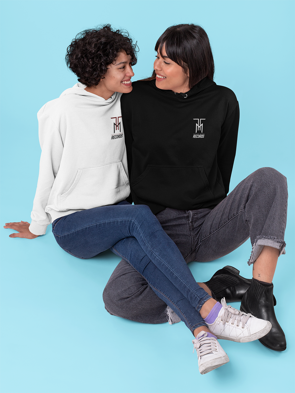 pullover-hoodie-mockup-of-a-couple-sitting-in-a-studio-30400.png