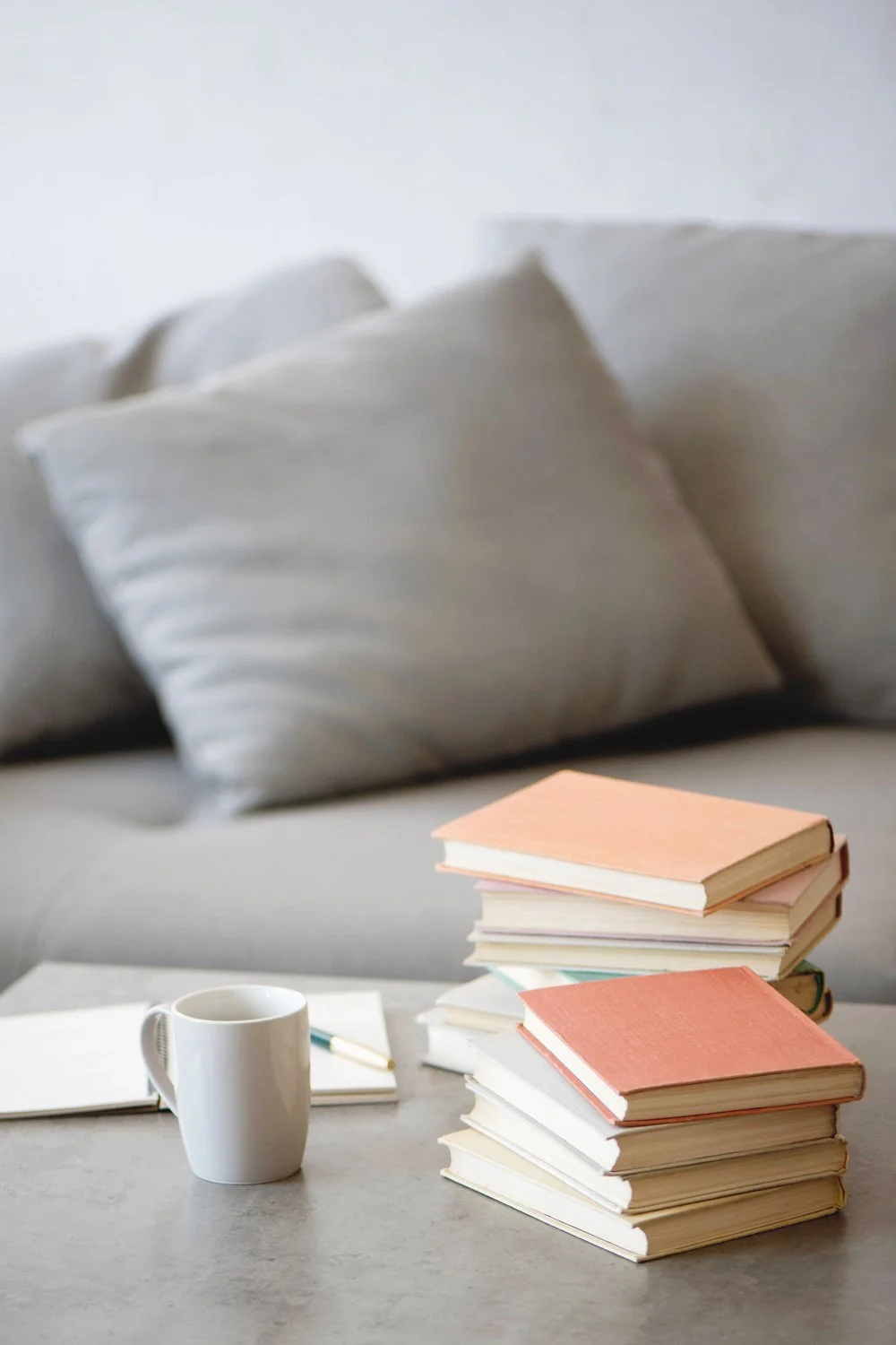 stacked piles of hardcover books and a notebook representing an author researching self-publishing copyright page text.