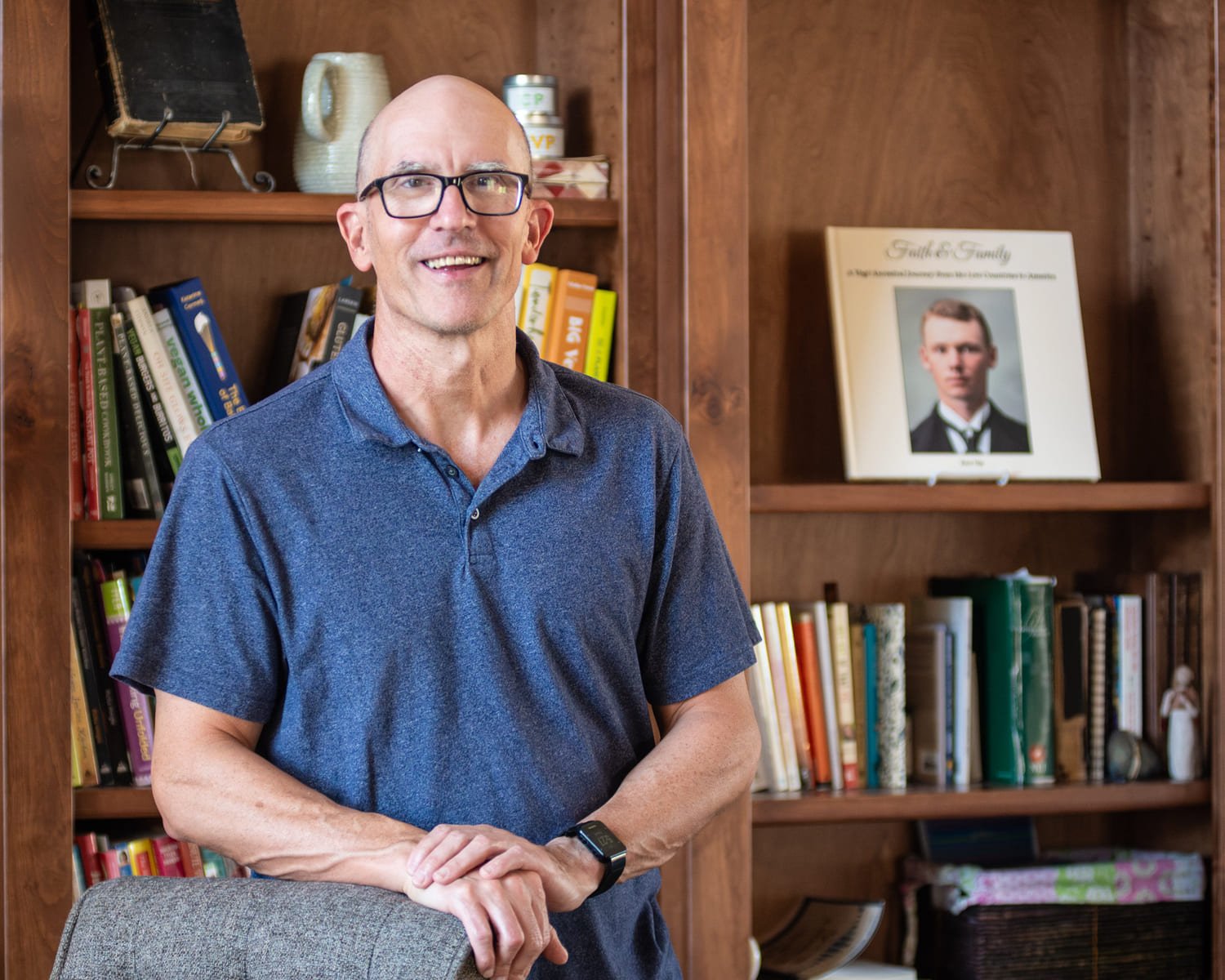 An author poses with a family history book he published after working with an editor.