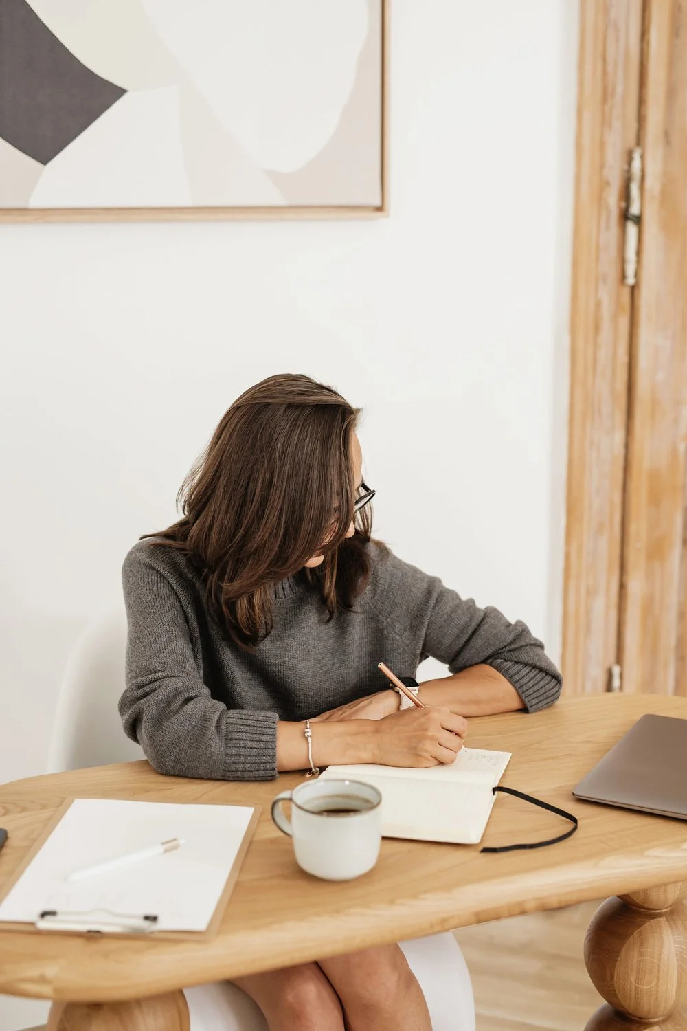 A woman writing in a notebook, meant to represent an author learning how to traditionally publish and the steps in publishing process