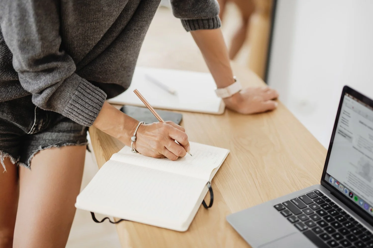 An author writes in a notebook while finding a literary agent for a nonfiction book proposal she is writing; part of an article about traditional publishing process