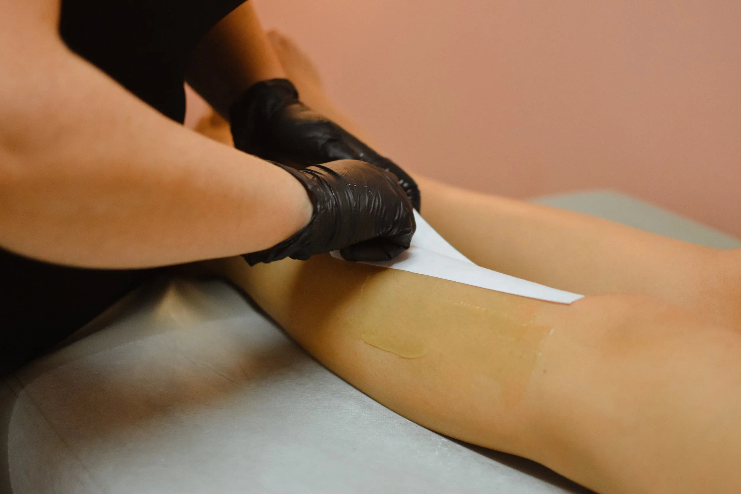 Heather Roberts, licensed esthetician, waxing a client's lower legs with strip wax