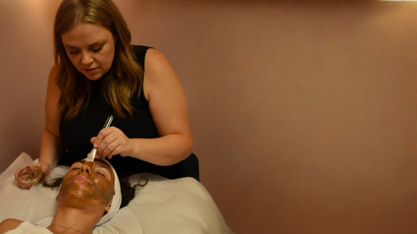 heather roberts applying a chocolate mask to a client laying on a facial table