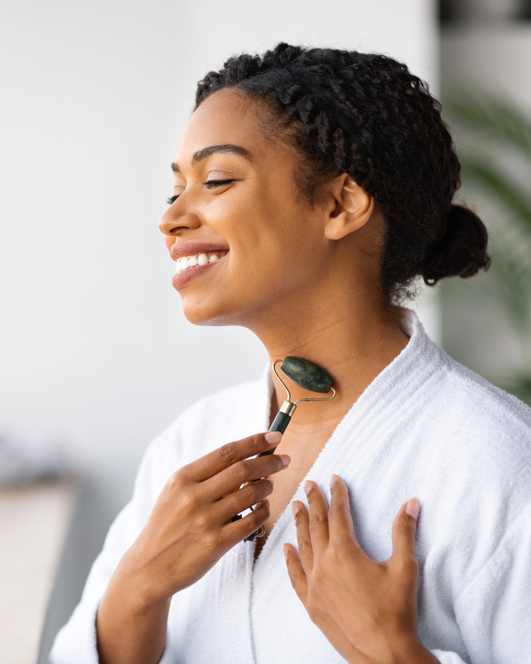 Woman using a jade roller on her face
