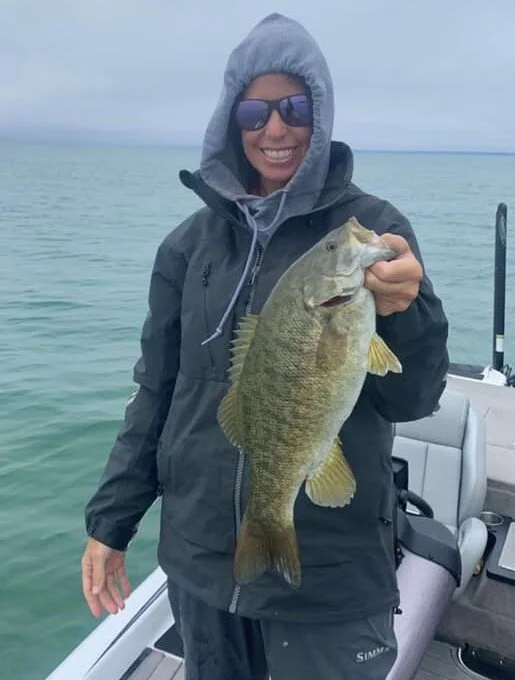 Arkansas WBT female angler with a monster northern smallmouth caught while wearing Simms rain protection