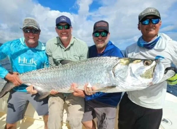 Four anglers holding a tarpon off Pacific coast of Panama