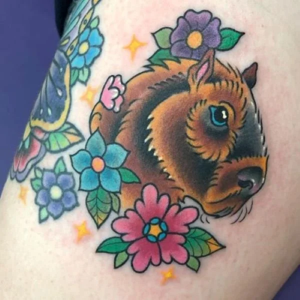 Colorful tattoo of flowers around a capybara